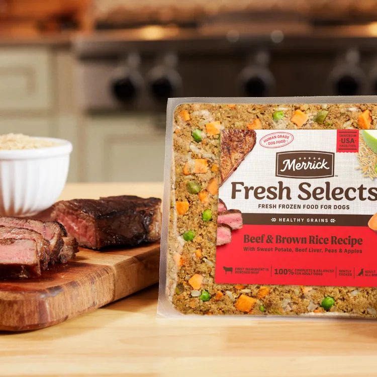 Real Chick and sweet potato kibble and Fresh Selects on table next to cutting board of ingredients